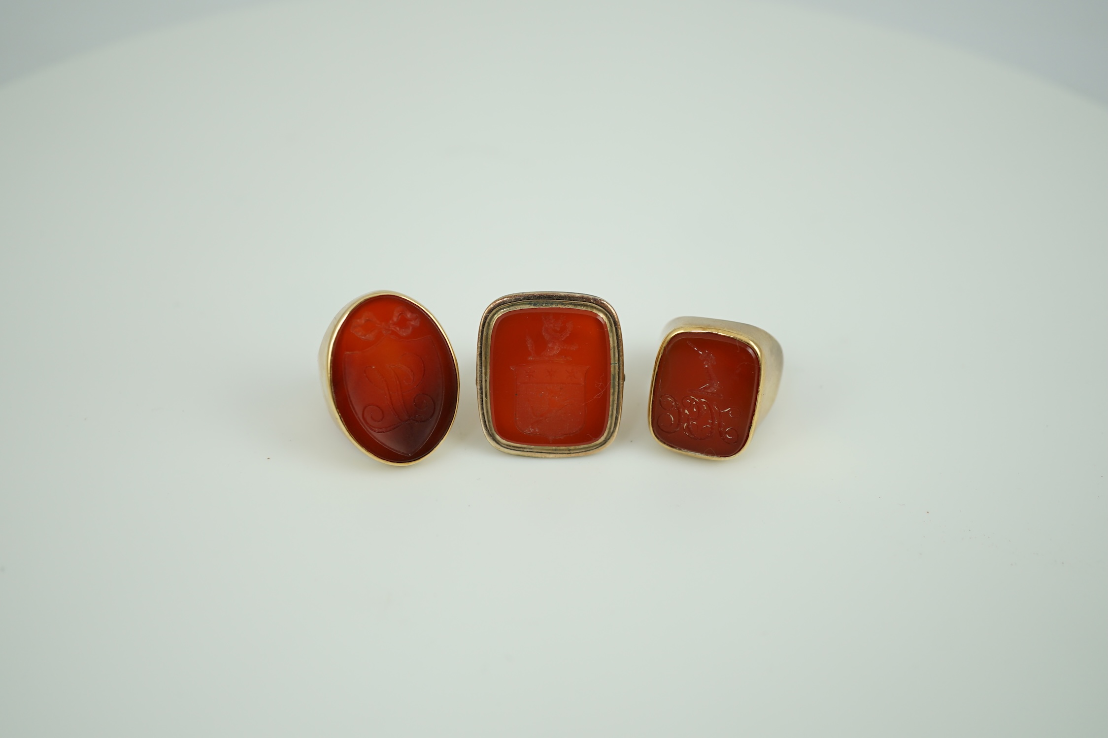 A Victorian 9ct and carnelian set intaglio ring, carved with a crest size L and two other similar yellow metal and carnelian intaglio ring, gross weight 35.8 grams.